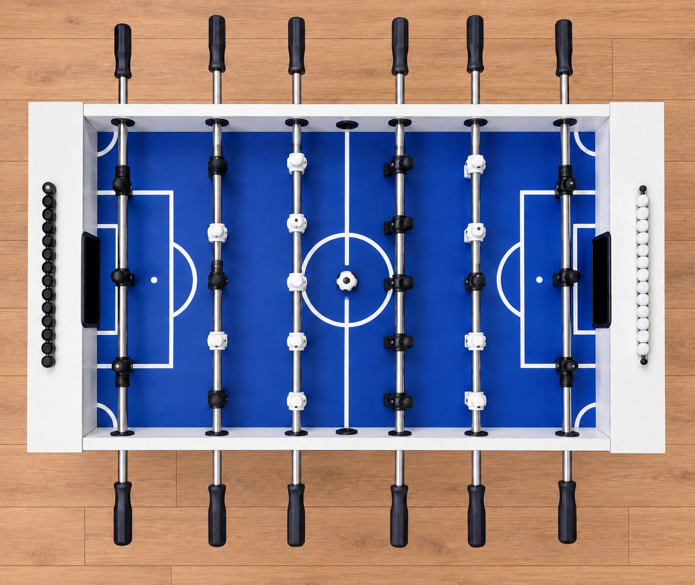 Overhead view of the foosball table on honey-oak flooring